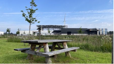 Zicht op een picknickbank en een bedrijf op het terrein van Doorn Noord